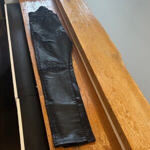 Amiri black wax coated denim with leather repair inserts and distressed detail